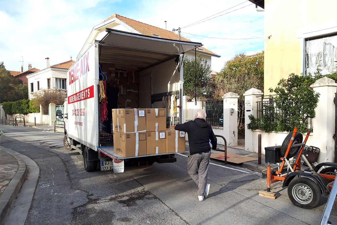 Déménageur de Démé-Aix chargeant des cartons dans un camion de déménagement