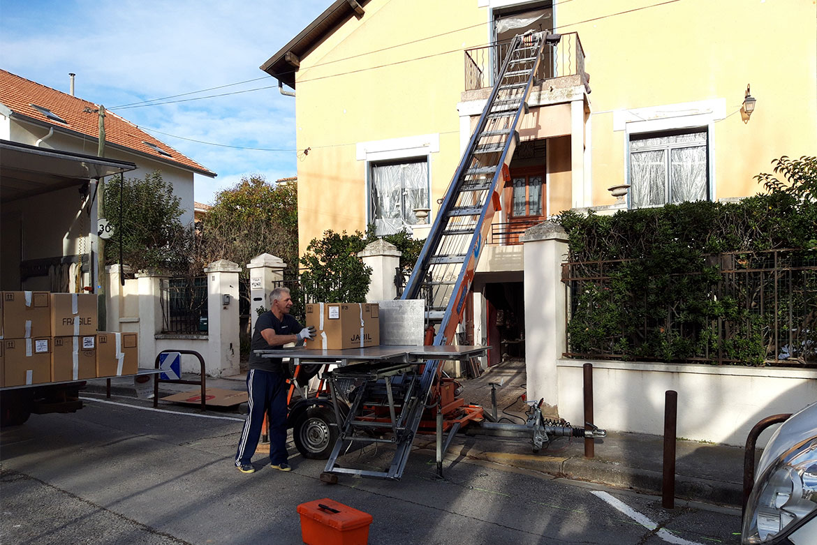 Déménageur de Démé-Aix utilisant un monte-meuble pour transporter des cartons