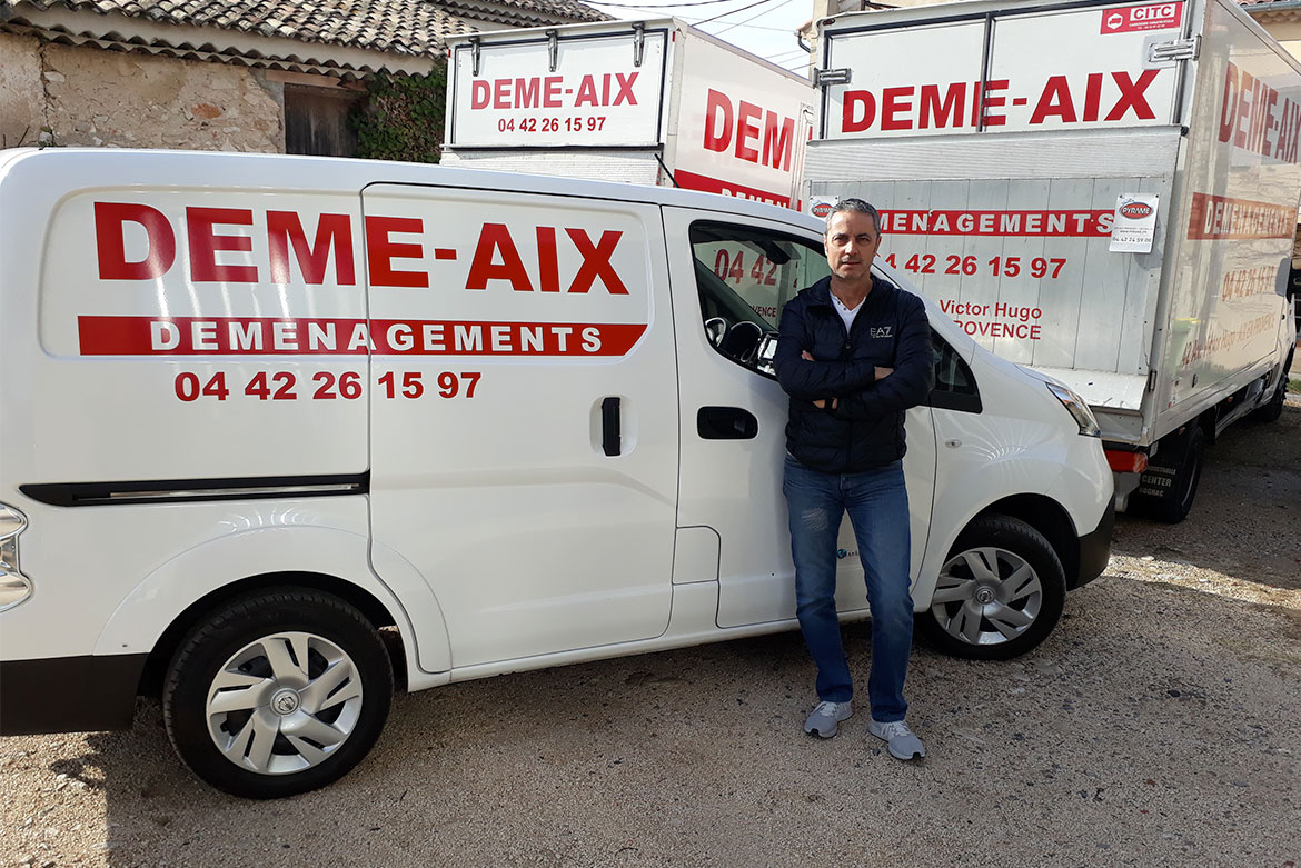 Gérant de Démé-Aix devant la flotte de véhicules de déménagement